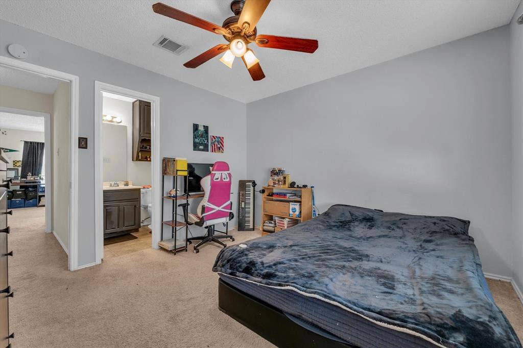 1349 S 11th Street, Waco, TX 76706 Bedroom with light carpet, ensuite bathroom, and a ceiling fan