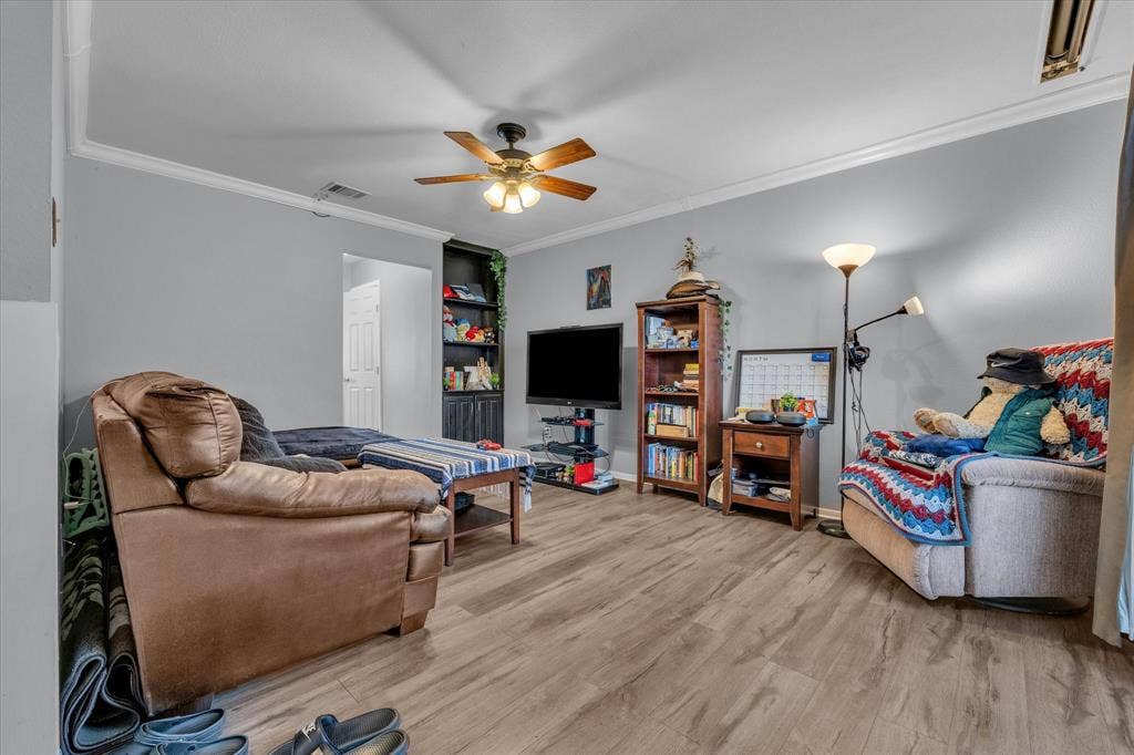 1349 S 11th Street, Waco, TX 76706 Living room with crown molding, light wood-type flooring, and a ceiling fan