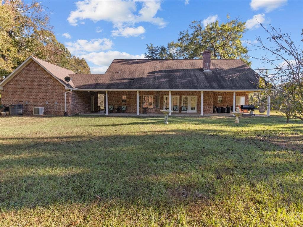 20941 Fm 16 W, Lindale, TX 75771 Back of house with a yard, a patio, brick siding, and a chimney