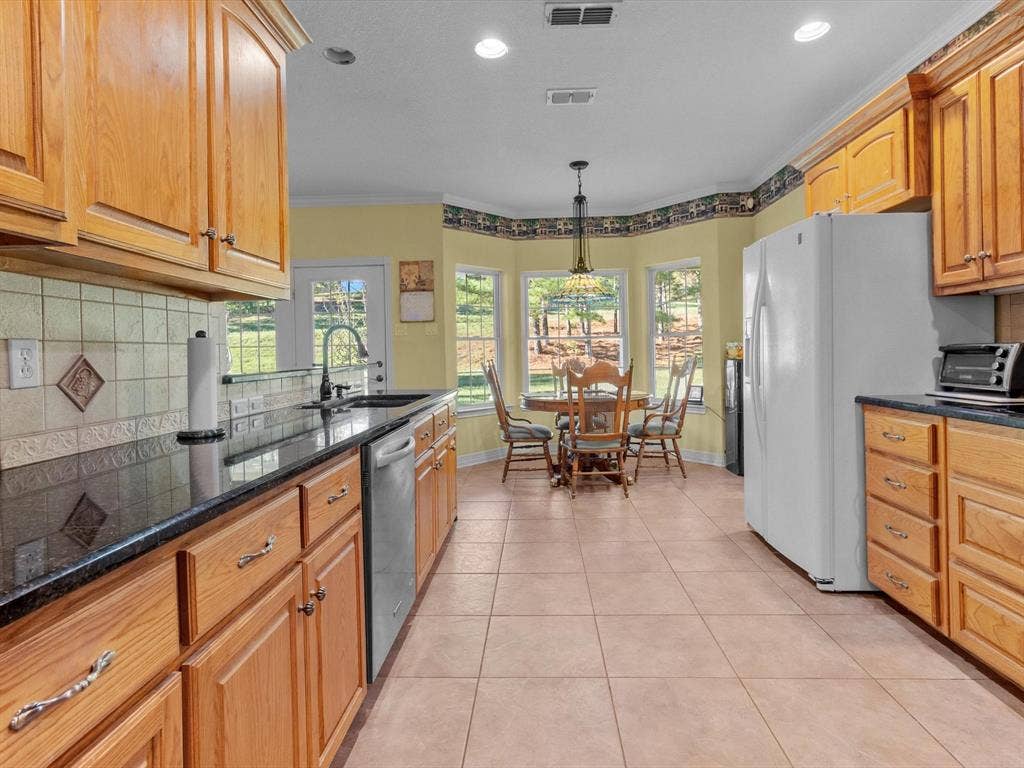 20941 Fm 16 W, Lindale, TX 75771 Kitchen with backsplash, decorative light fixtures, white refrigerator with ice dispenser, light tile patterned flooring, and dishwasher