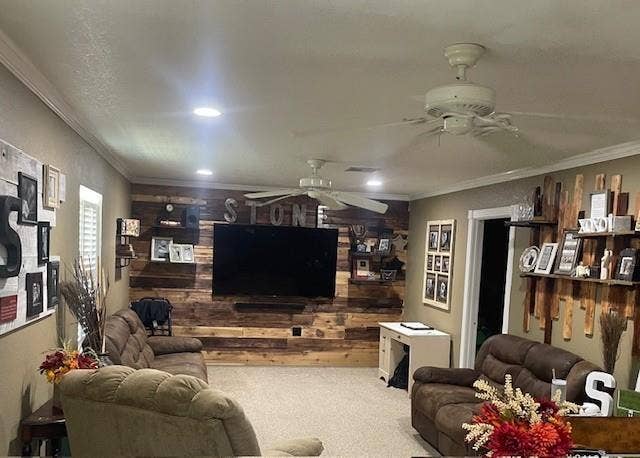 Living room with ornamental molding, carpet flooring, wooden walls, recessed lighting, and a textured ceiling
