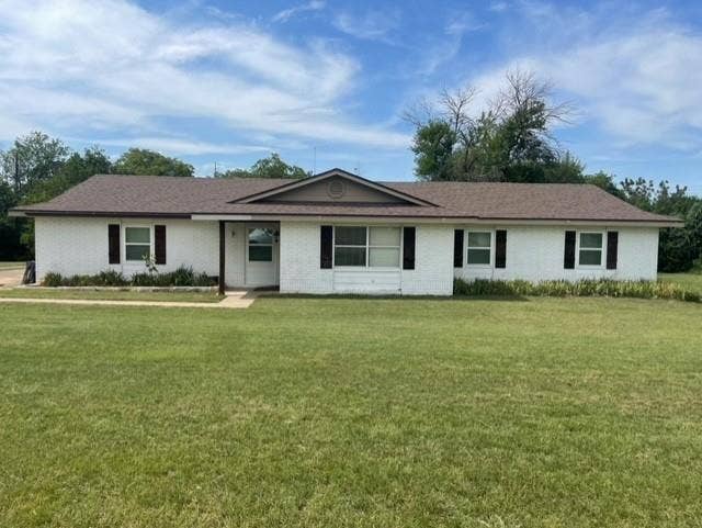Single story home with brick siding and a front lawn