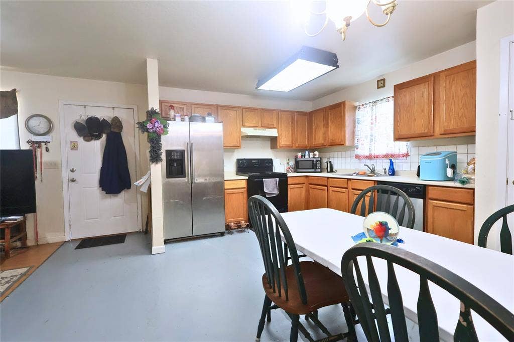 14186 Austin Street, Log Cabin, TX 75148 Kitchen with light countertops, appliances with stainless steel finishes, finished concrete flooring, and brown cabinets