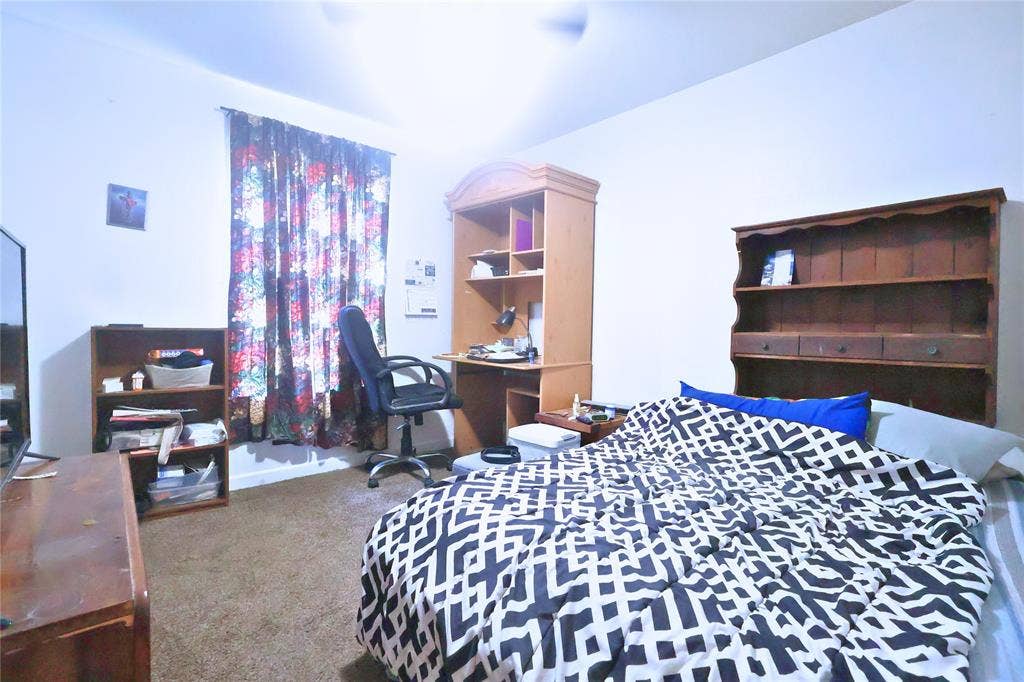 14186 Austin Street, Log Cabin, TX 75148 Bedroom featuring light colored carpet, a desk, and a ceiling fan