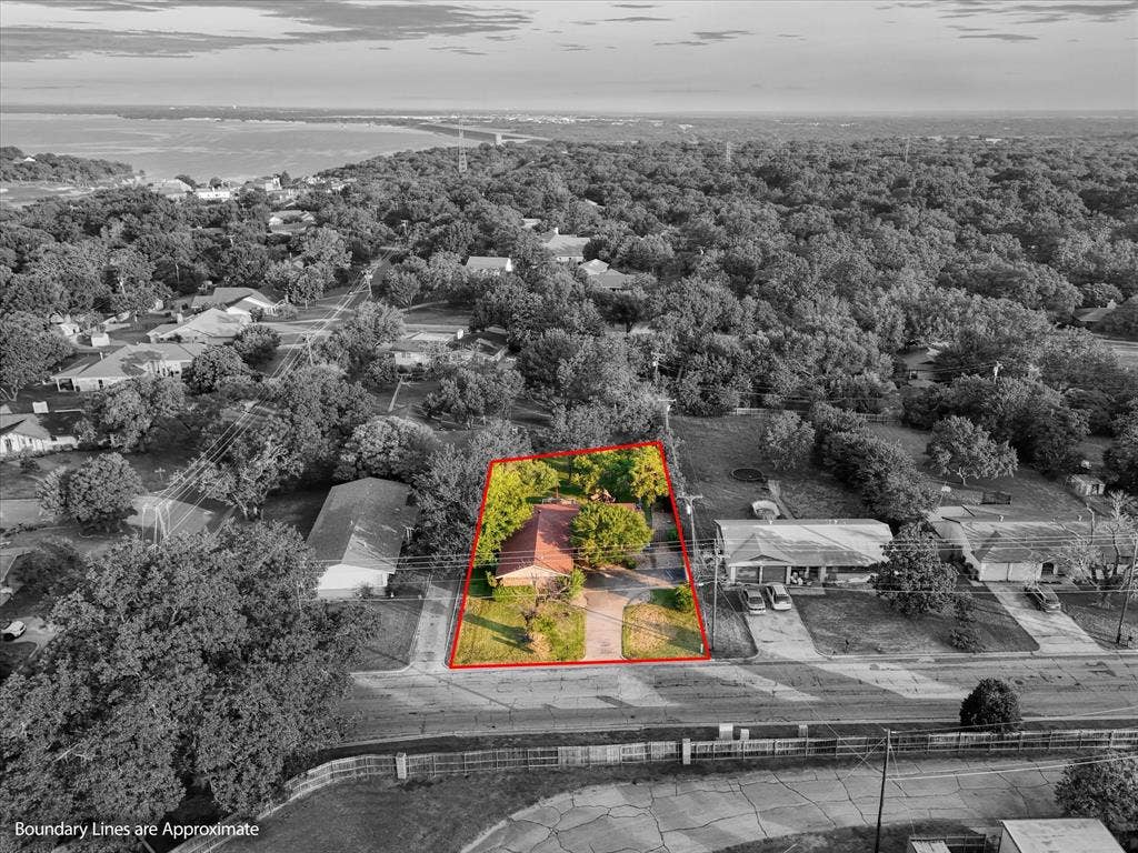 3405 Edna Avenue, Waco, TX 76708 Aerial perspective of suburban area with a heavily wooded area and property boundaries highlighted