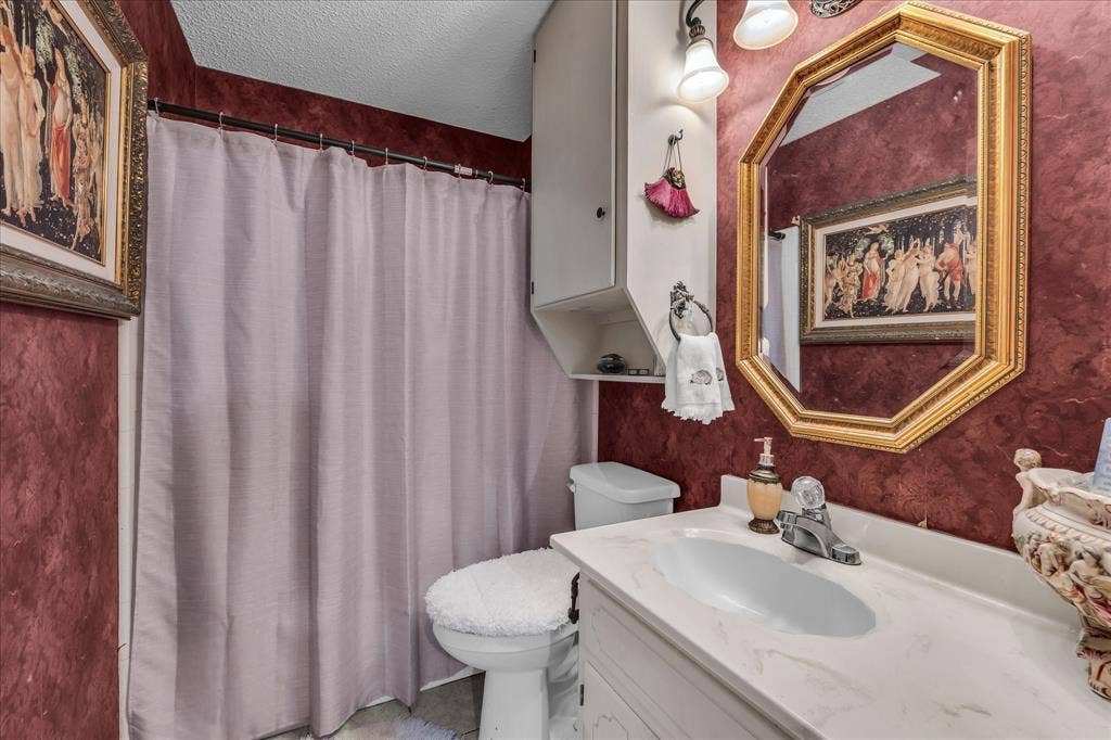 3405 Edna Avenue, Waco, TX 76708 Full bath with a textured ceiling, vanity, and curtained shower