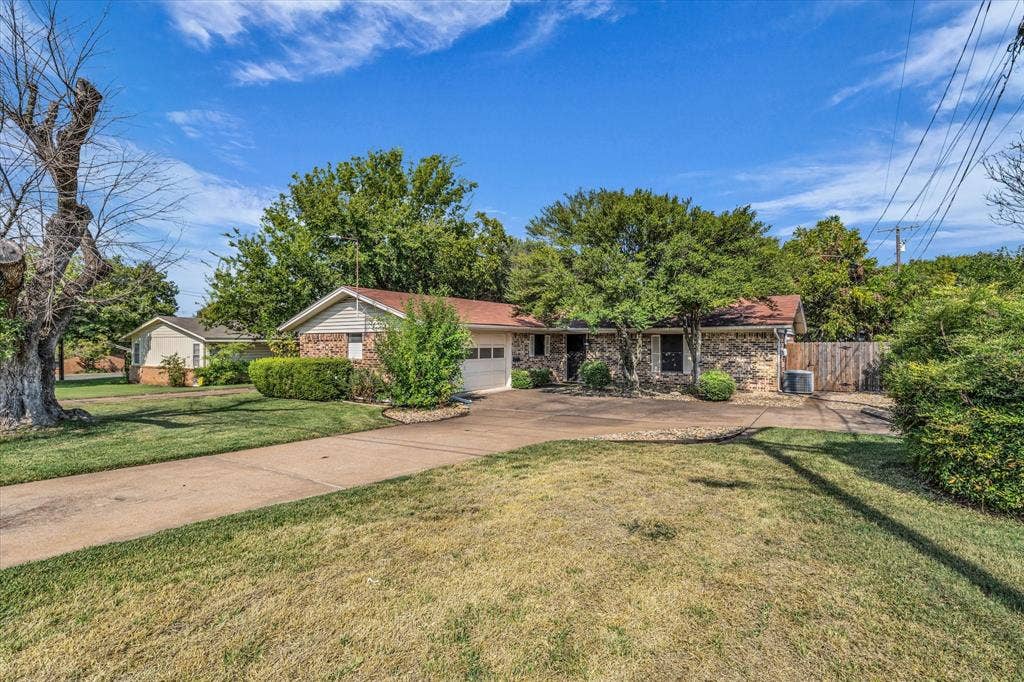 3405 Edna Avenue, Waco, TX 76708 Ranch-style house with brick siding, concrete driveway, and an attached garage