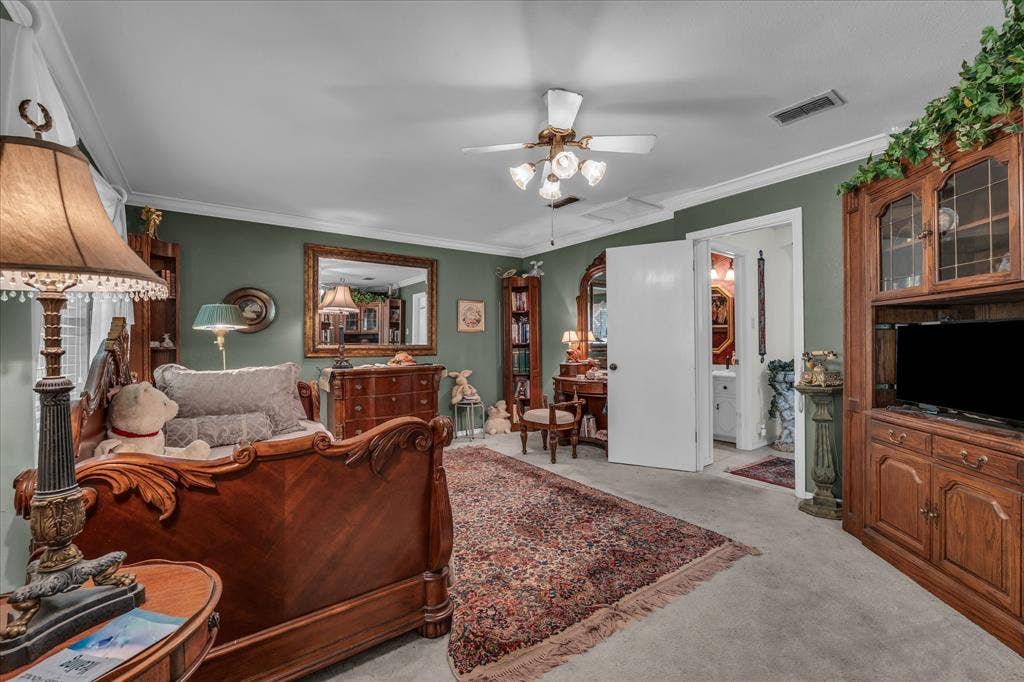3405 Edna Avenue, Waco, TX 76708 Living area with crown molding, light colored carpet, and a ceiling fan
