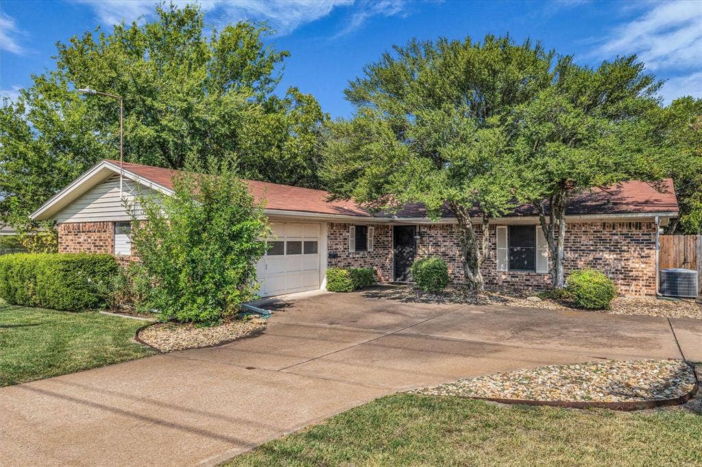 3405 Edna Avenue, Waco, TX 76708 Ranch-style home with brick siding, driveway, and a garage