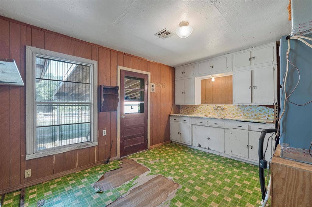 12145 Tree Lake Drive, Waco, TX 76708 Kitchen featuring wood walls, light floors, and light stone countertops