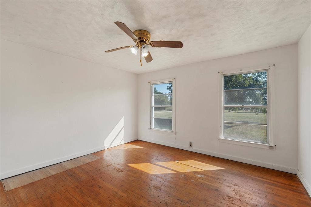 12145 Tree Lake Drive, Waco, TX 76708 Spare room featuring hardwood / wood-style floors, healthy amount of natural light, a textured ceiling, and a ceiling fan