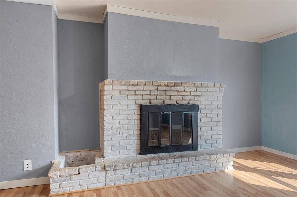 12145 Tree Lake Drive, Waco, TX 76708 Detailed view of a brick fireplace and wood finished floors