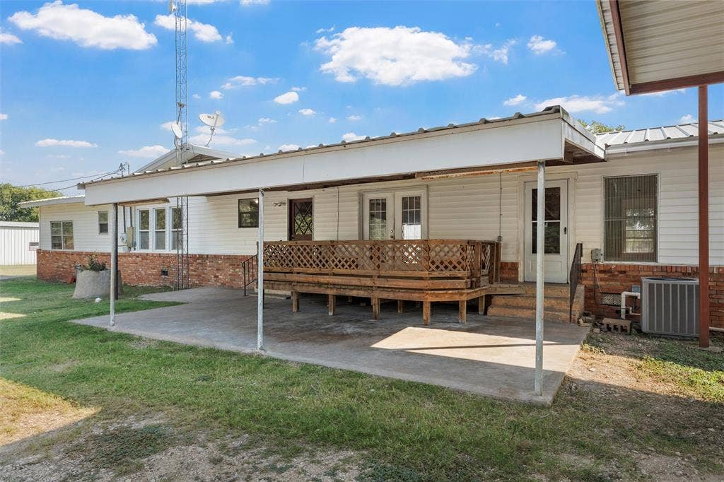 12145 Tree Lake Drive, Waco, TX 76708 Rear view of house with a metal roof, brick siding, a yard, and a patio