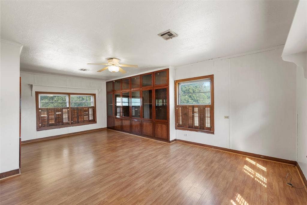 12145 Tree Lake Drive, Waco, TX 76708 Unfurnished living room featuring healthy amount of natural light, light wood-style floors, ceiling fan, and crown molding