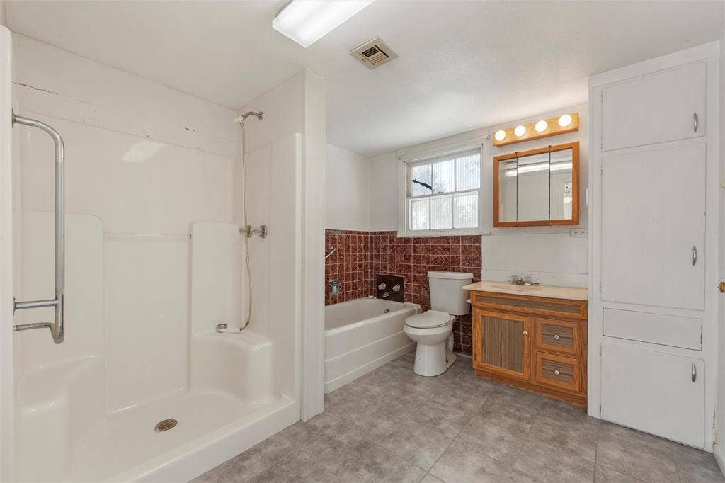 12145 Tree Lake Drive, Waco, TX 76708 Full bath featuring a stall shower, vanity, tile walls, light tile patterned floors, and a garden tub