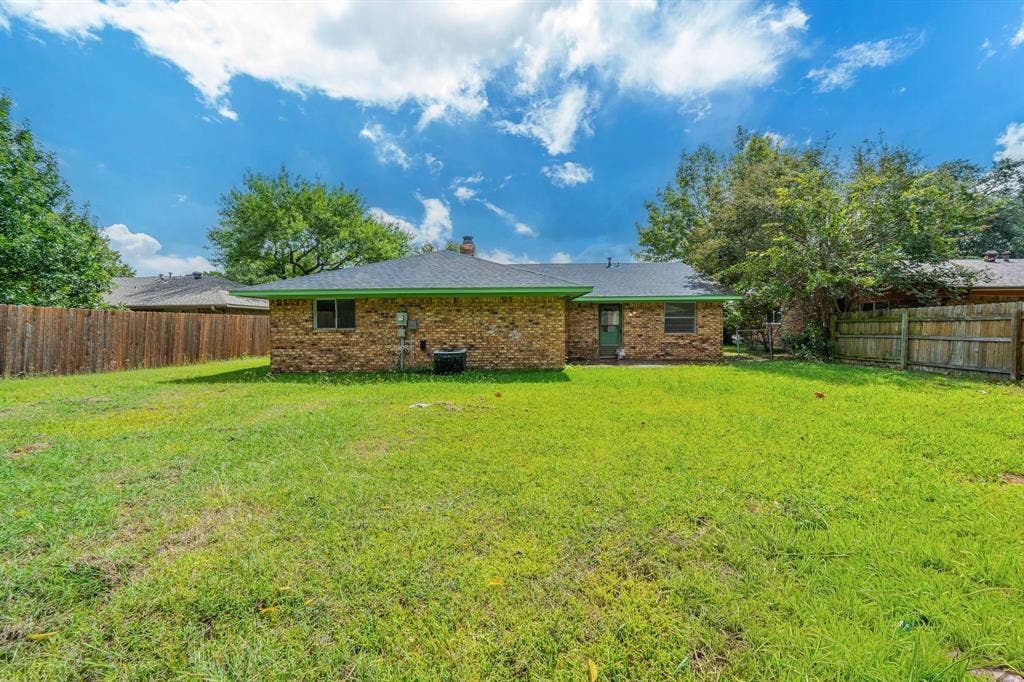 105 Briar Lane, Waxahachie, TX 75165 Rear view of property featuring a partial fenced backyard, brick siding, and a chimney