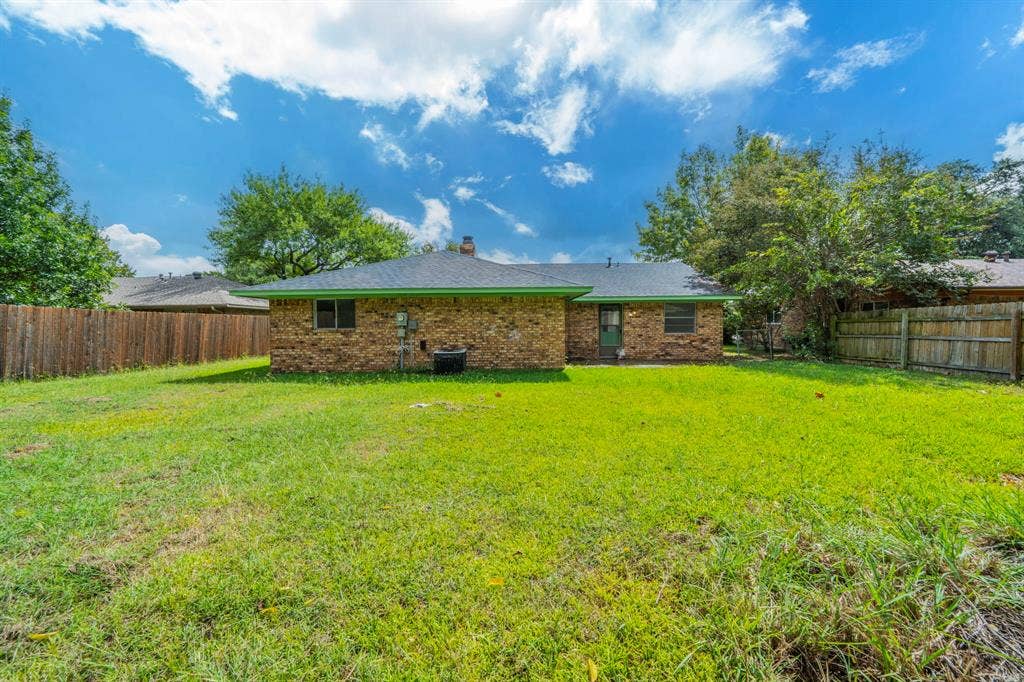 105 Briar Lane, Waxahachie, TX 75165 Rear view of property with a fenced backyard, brick siding, a chimney, and a shingled roof