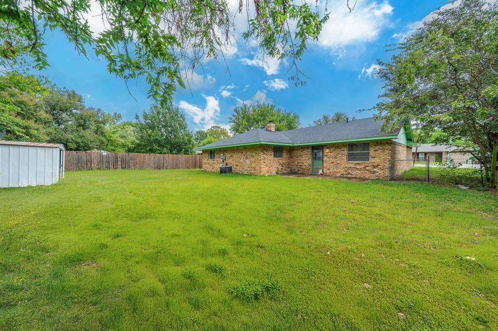 105 Briar Lane, Waxahachie, TX 75165 Partially Fenced backyard featuring a storage unit