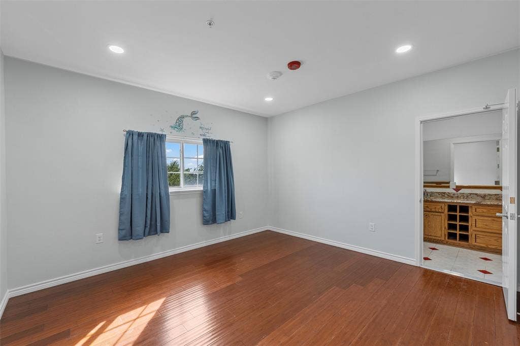 Empty room featuring dark wood finished floors and recessed lighting