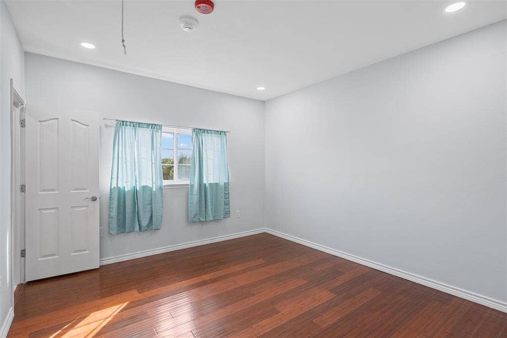 Unfurnished room with dark wood finished floors and recessed lighting