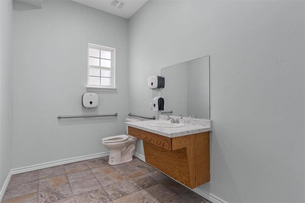 Bathroom with vanity and light stone finish floors