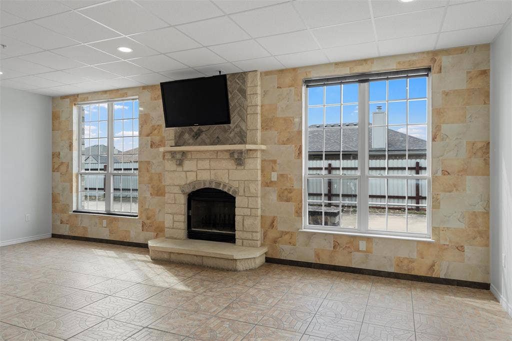 Unfurnished living room with a fireplace and a drop ceiling
