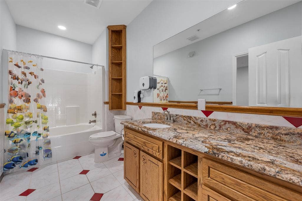 Bathroom featuring shower / tub combo, light tile patterned floors, vanity, and recessed lighting