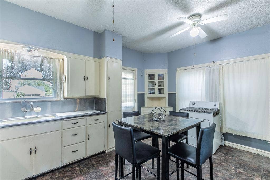 2603 Pine Avenue, Waco, TX 76708 Kitchen with a textured ceiling, stone finish flooring, a ceiling fan, and white cabinets