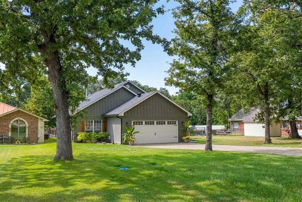 127 Rueda Encina Street, Gun Barrel City, TX 75156 View of front of home with a front lawn, board and batten siding, an attached garage, and concrete driveway