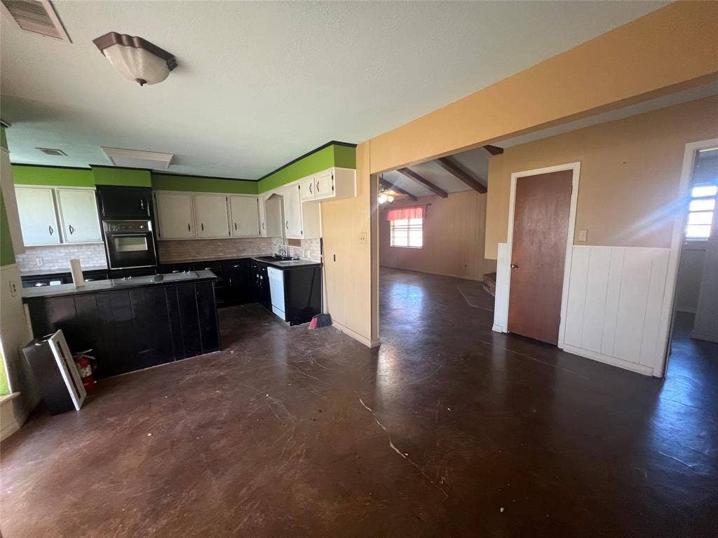 4038 State Highway 351, Abilene, TX 79601 Kitchen with tasteful backsplash, black oven, ceiling fan, dark cabinets, and white cabinets