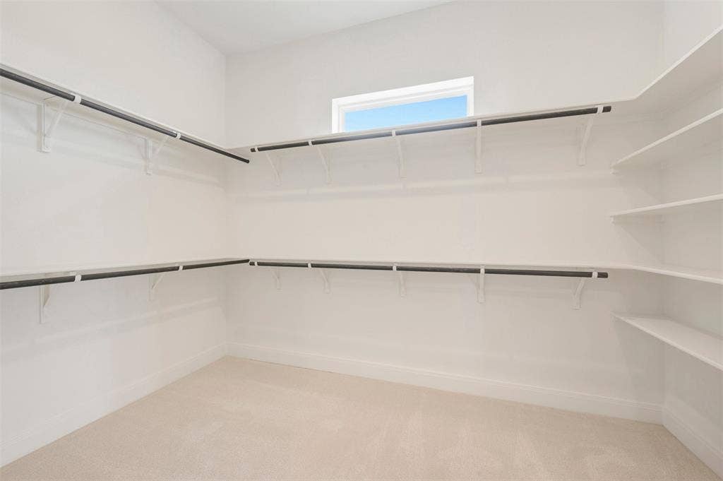 Spacious walk-in closet featuring extensive shelving and hanging rods