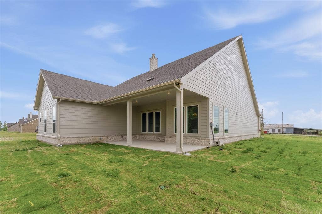 9007 County Road 623, Blue Ridge, TX 75424 Rear view of property with roof with shingles, a patio area, a lawn, and a chimney