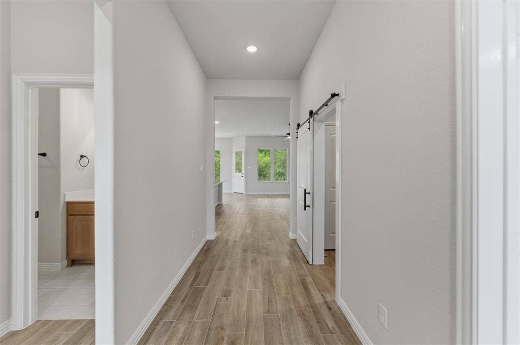 9007 County Road 623, Blue Ridge, TX 75424 Hall with wood tiled floors, a barn door, and recessed lighting