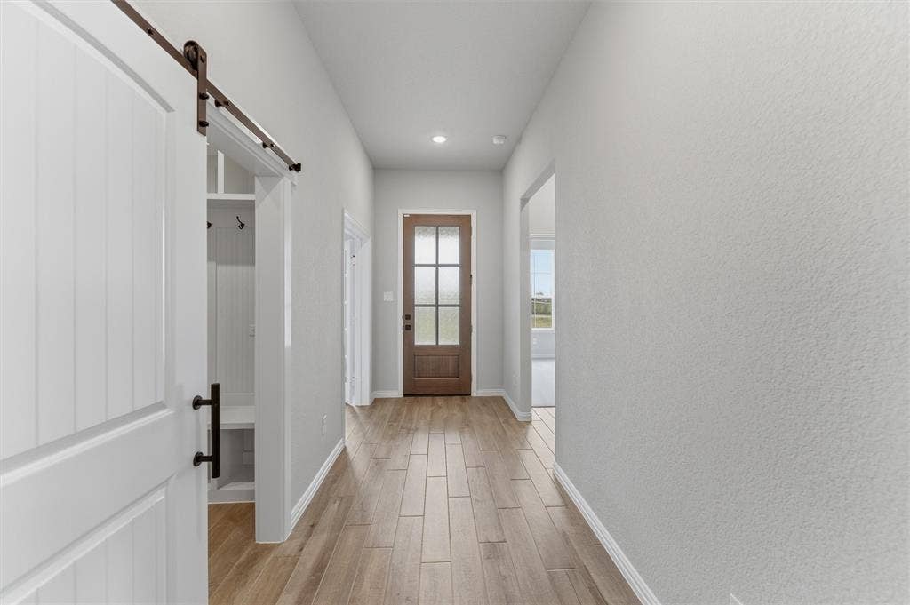9007 County Road 623, Blue Ridge, TX 75424 Doorway with a barn door, wood finish floors, and recessed lighting