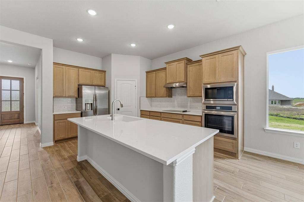 9007 County Road 623, Blue Ridge, TX 75424 Kitchen featuring stainless steel appliances, an island with sink, decorative backsplash, light wood-style floors, and recessed lighting