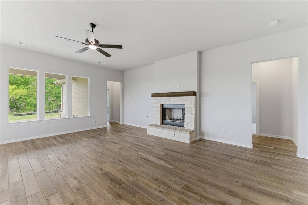 9007 County Road 623, Blue Ridge, TX 75424 Unfurnished living room with a ceiling fan, light wood-style flooring, and a stone fireplace