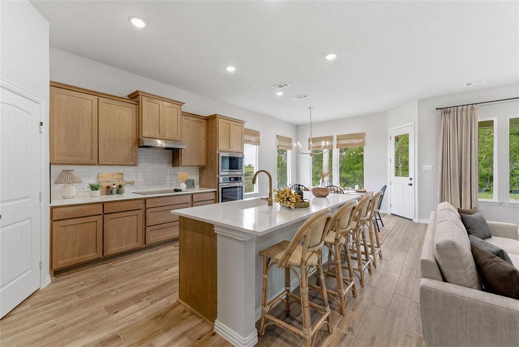 9007 County Road 623, Blue Ridge, TX 75424 Open-concept kitchen and living area featuring wood-finish flooring, recessed lighting, and a white tile backsplash