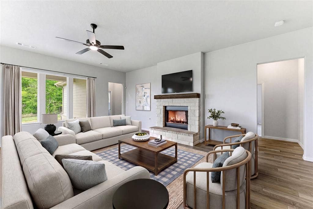 9007 County Road 623, Blue Ridge, TX 75424 Living area featuring a stone-clad fireplace with a wood mantel, wood-finish flooring, and multiple windows
