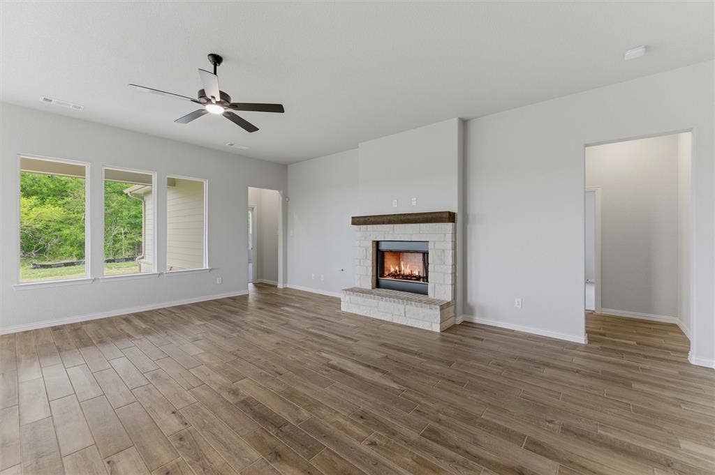 9007 County Road 623, Blue Ridge, TX 75424 Unfurnished living room featuring a ceiling fan, a fireplace, and light wood-style floors
