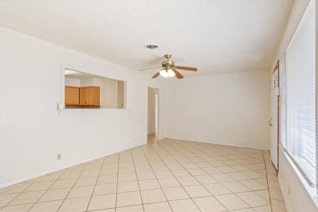 2424 S 26th Street, Waco, TX 76706 Unfurnished room featuring a textured ceiling, light tile patterned floors, and ceiling fan