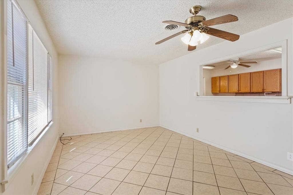 2424 S 26th Street, Waco, TX 76706 Spare room featuring a textured ceiling, light tile patterned floors, and a ceiling fan
