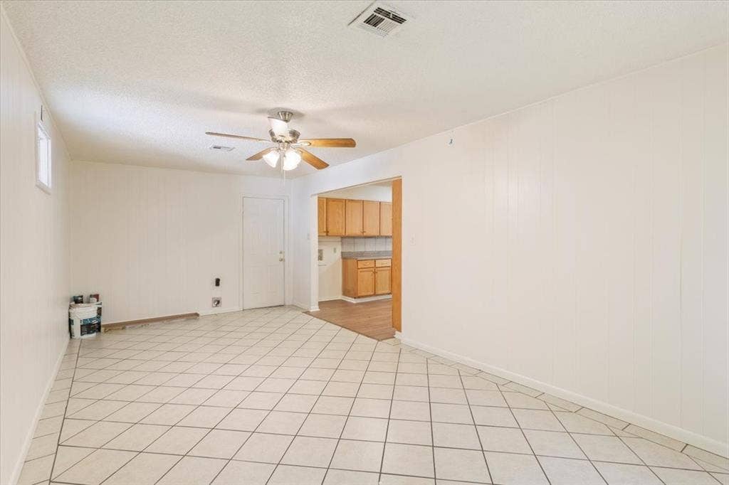 2424 S 26th Street, Waco, TX 76706 Unfurnished room featuring ceiling fan, light tile patterned flooring, and a textured ceiling