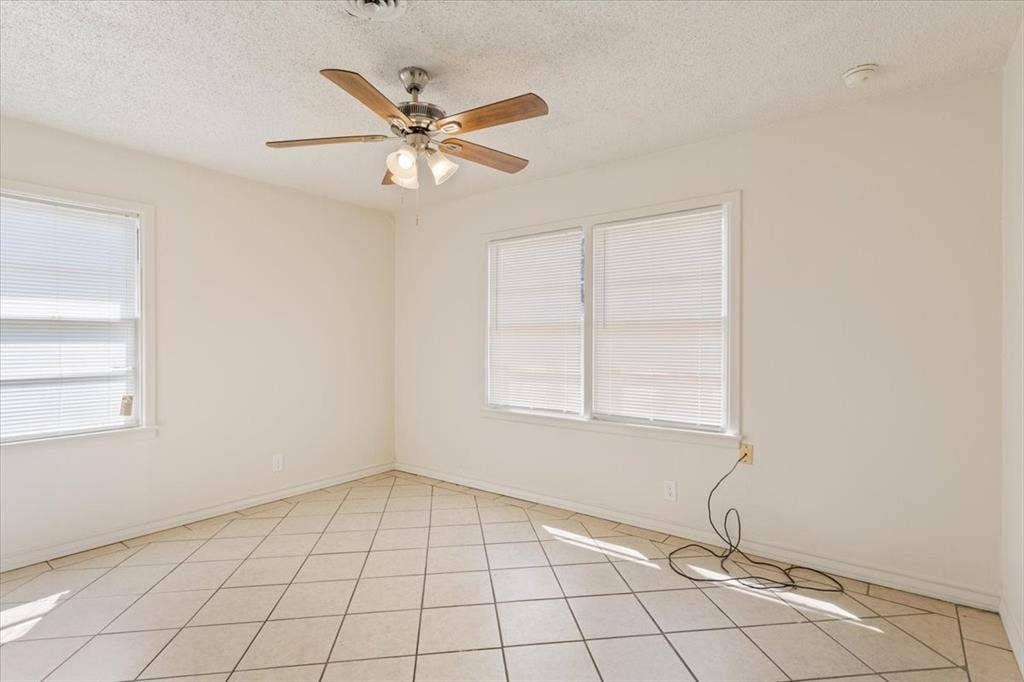 2424 S 26th Street, Waco, TX 76706 Unfurnished room with a textured ceiling, light tile patterned flooring, and a ceiling fan