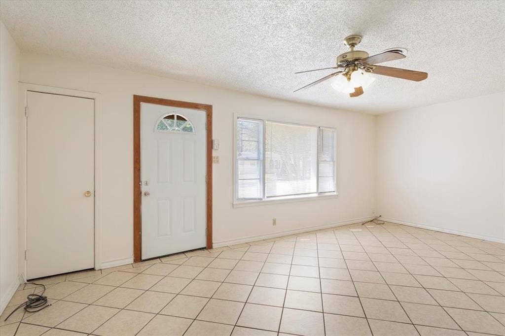 2424 S 26th Street, Waco, TX 76706 Foyer entrance featuring a textured ceiling, ceiling fan, and light tile patterned floors
