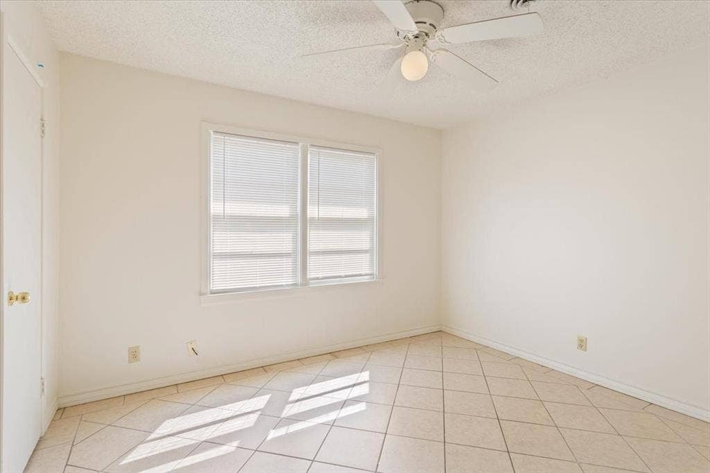 2424 S 26th Street, Waco, TX 76706 Unfurnished room with a textured ceiling, light tile patterned floors, and a ceiling fan
