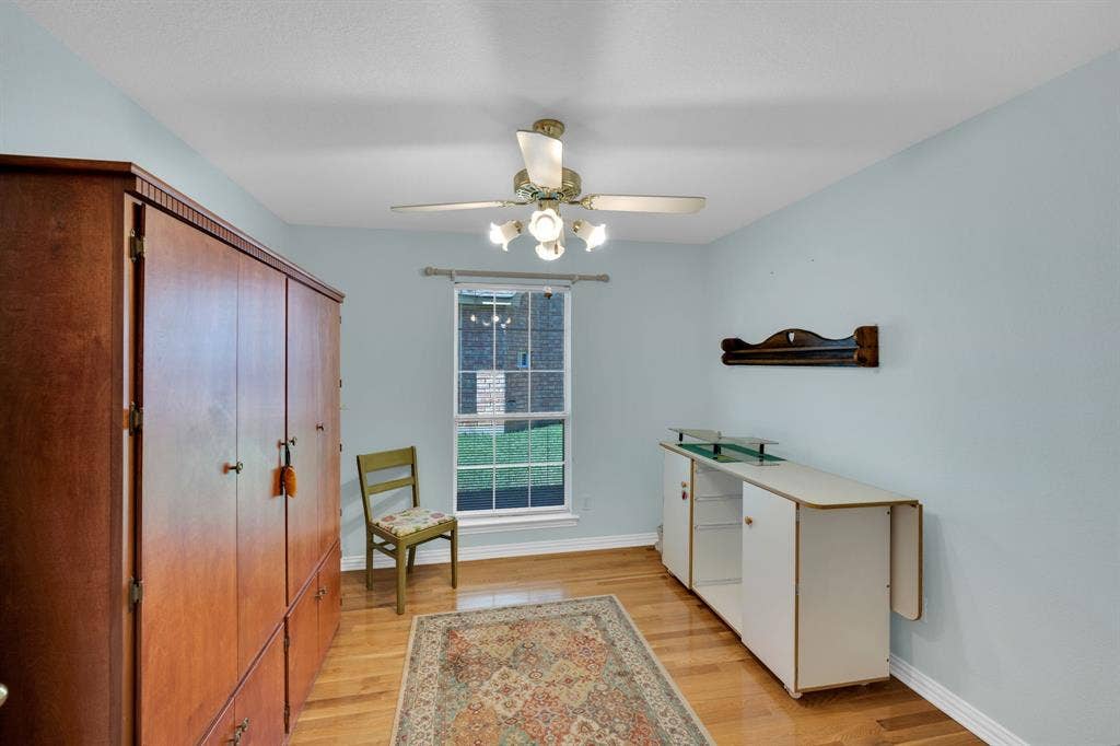 room with light wood-style floors and a ceiling fan
