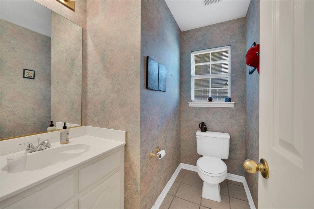 Half bathroom featuring light tile patterned floors and vanity