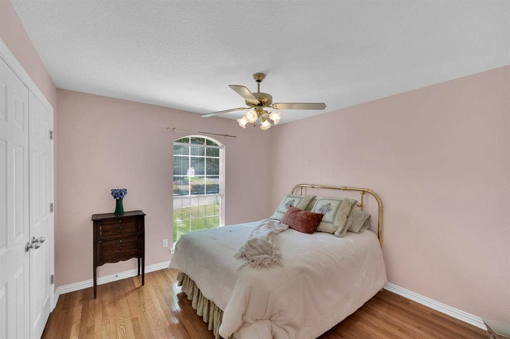Bedroom with light wood finished floors, a closet, and a ceiling fan