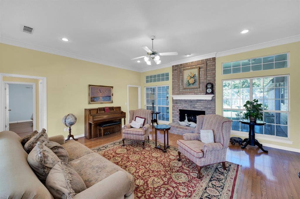 Living room featuring ornamental molding, hardwood / wood-style floors, a fireplace, recessed lighting, and ceiling fan