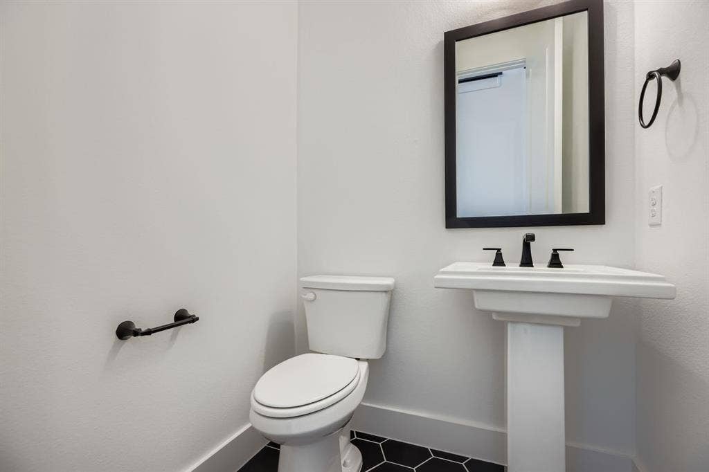 Bathroom with baseboards and dark tile patterned flooring